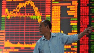 An investor watches the electronic board at a stock exchange hall in Fuyang, China.